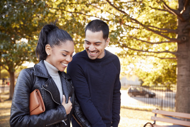 Young Hispanic couple walking hand in hand in Brooklyn park | Center ...